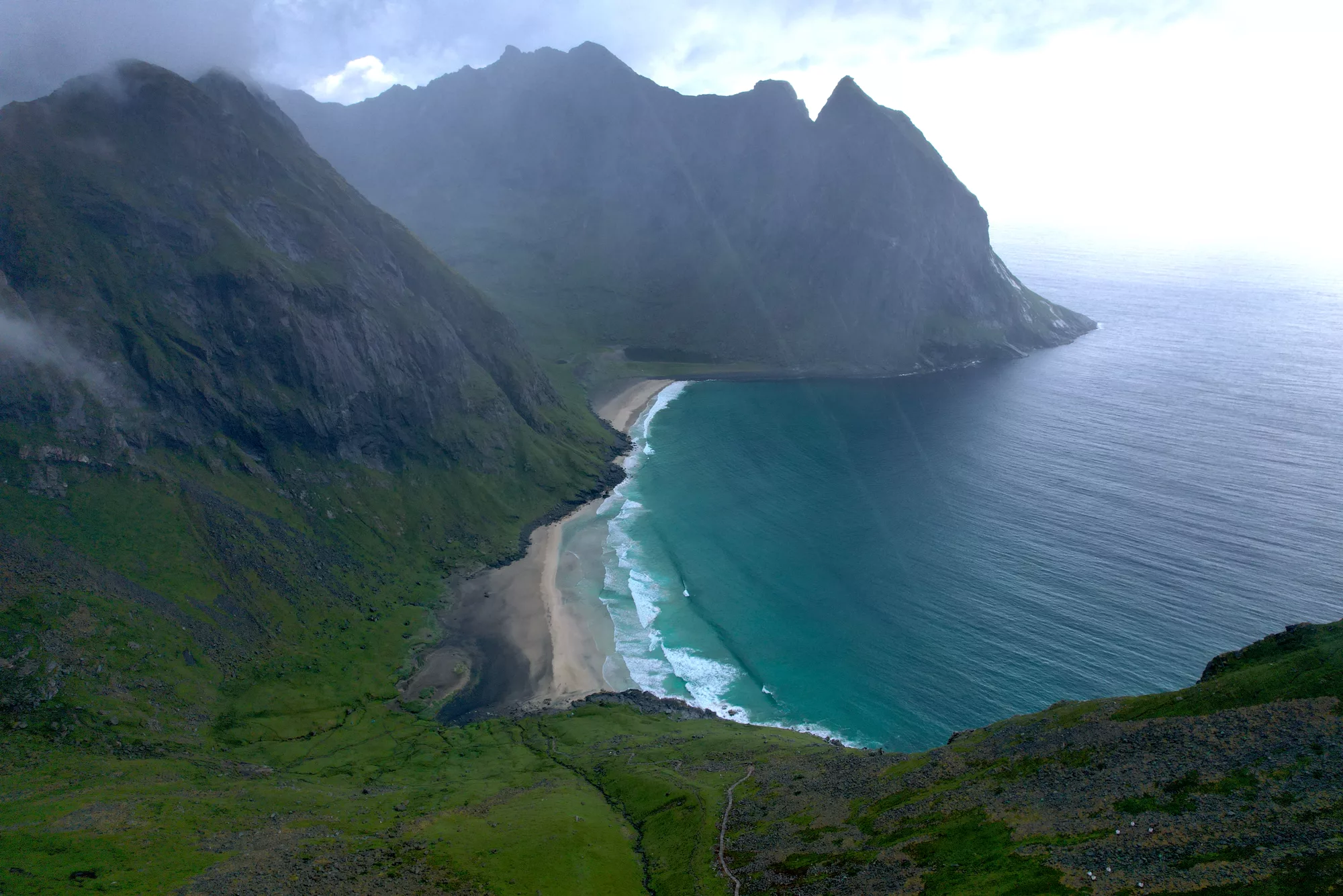 Our aerial photo of Kvalvika Beach — turquoise water and pale sand framed by steep green mountains, Lofoten