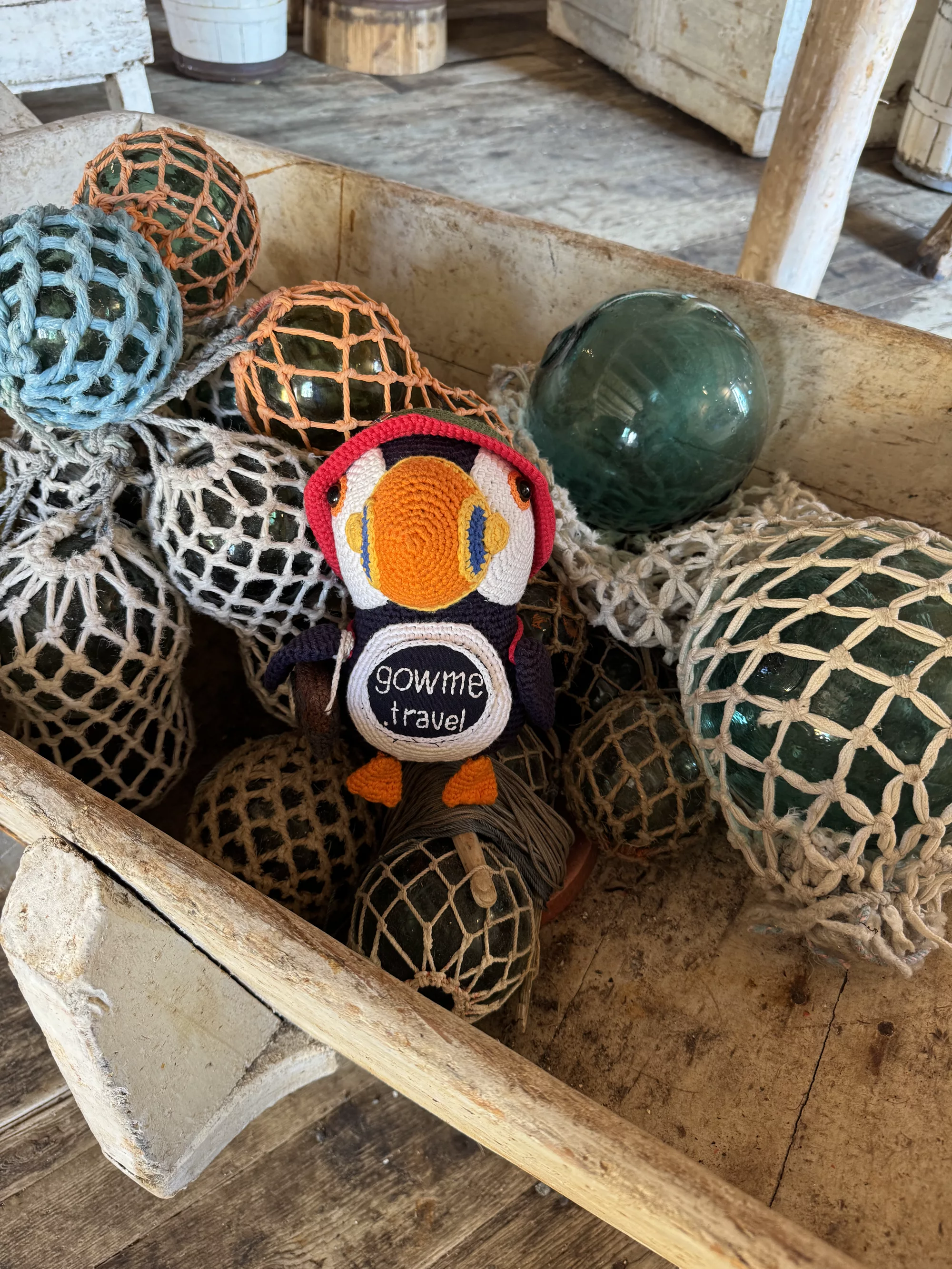 Our Gowme.travel mascot among traditional glass fishing floats in Nusfjord, Lofoten