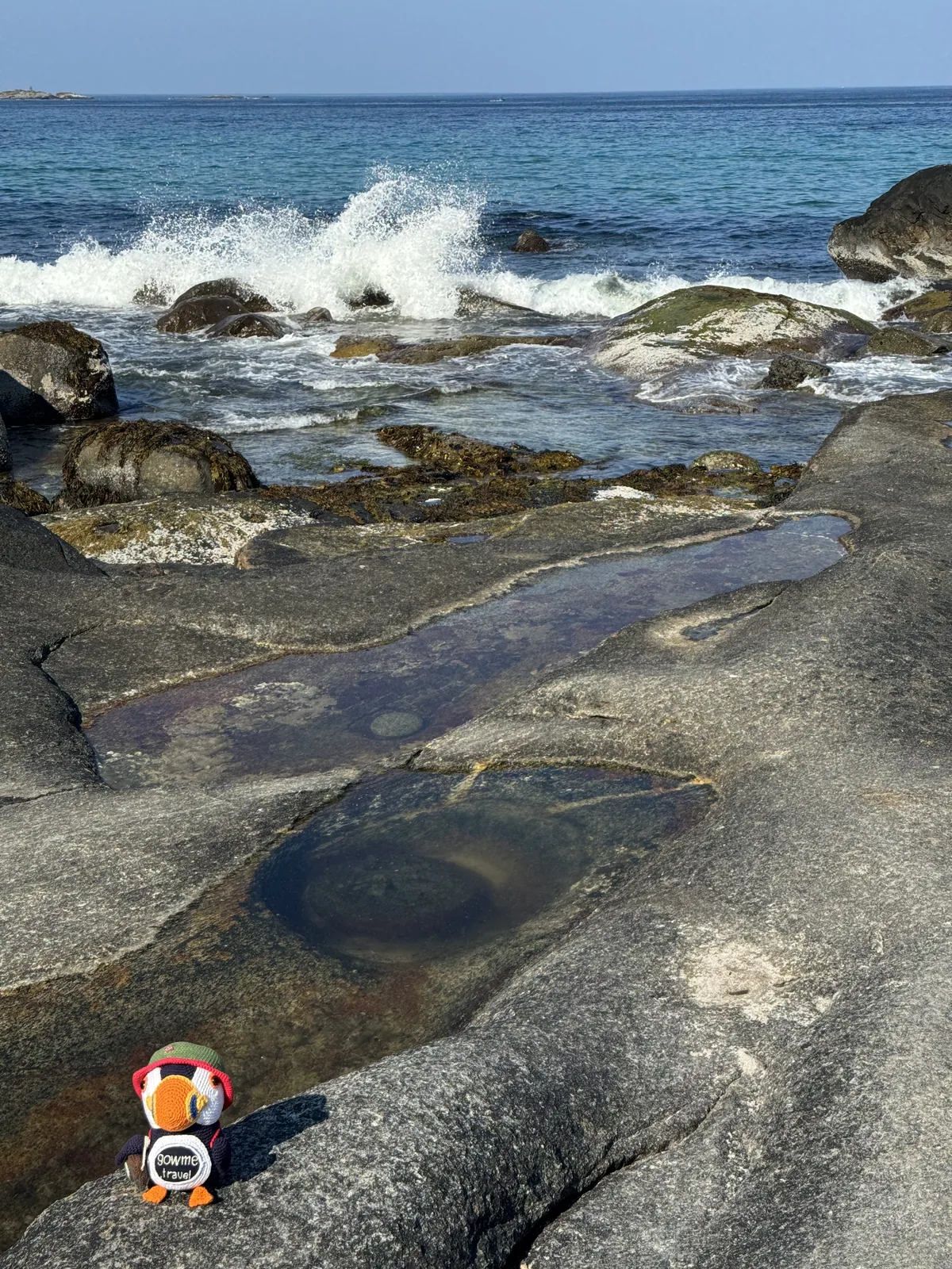 Our photo of the Dragon's Eye rock formation at Uttakleiv — a circular eye-shaped pool in the granite slab, with waves breaking behind